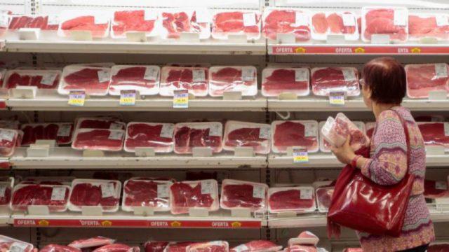 Consumidora analisa cortes de carne bovina em supermercado, carnes